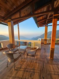 un patio con mesa y sillas en una terraza en Laspa Cottage, Bhimtal en Bhīm Tāl