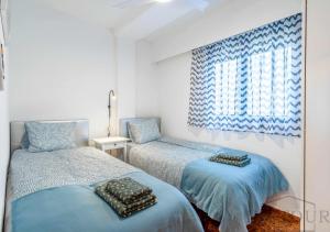 sypialnia z dwoma łóżkami i oknem w obiekcie Inftour Apolo Apartamento w mieście Calpe