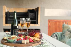 a table with two glasses of wine and a plate of food at The Olive Terrace in Cape Town