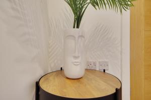 a vase sitting on a table with a plant in it at 279 Ashley Road in Parkstone