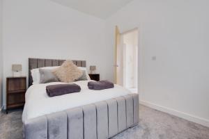 a bedroom with a large white bed with two pillows at 279 Ashley Road in Parkstone