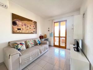 a living room with a couch and a tv at Sunset House La Cinta ST5 - PuntoCasaBudoni in San Teodoro