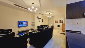 sala de estar con sillas y TV de pantalla plana en Perfect Vacation with 3bhk villa en Dubái