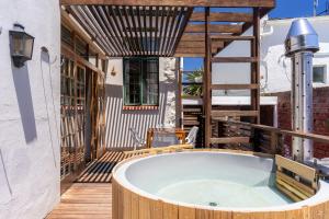 bañera de hidromasaje en la cubierta de una casa en Stone Cottages, en Ciudad del Cabo