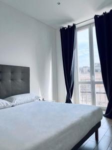 a bedroom with a large bed and a large window at Macario Apartment in the Old Town in Bari