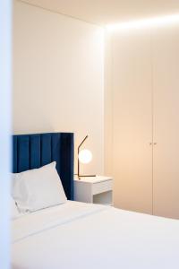 um quarto com uma cama com uma cabeceira azul e uma mesa em Pardal RC A - Luxury 2 Bed Apartment in Alcantara em Lisboa