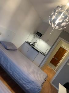 Habitación pequeña con cama y lámpara de araña. en Vandrarhem Köping en Köping