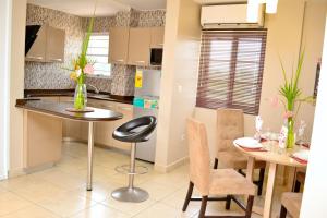 uma cozinha e sala de jantar com mesa e cadeiras em Acquah Place Residences em Acra