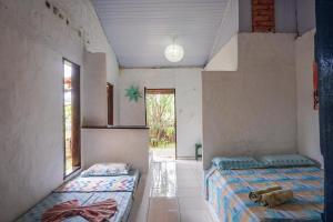 twee bedden in een kamer met twee ramen bij Pousada Mirage Atins in Atins