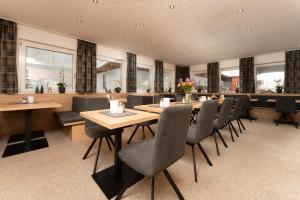 a dining room with wooden tables and chairs at Pension Sonnenheim in Sölden
