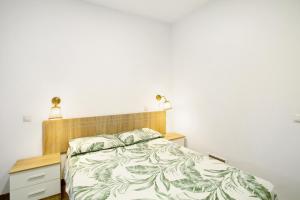 um quarto com uma cama e uma cabeceira em madeira em The Greey's House B em Telde