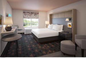 Holiday Inn Dallas Market Ctr Love Field, an IHG Hotel في دالاس: غرفة في الفندق مع سرير ومكتب