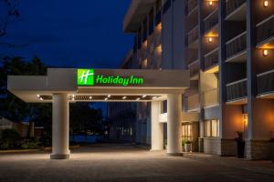 Holiday Inn Dallas Market Ctr Love Field, an IHG Hotel في دالاس: مبنى مع علامة هيلتون هامبتون في الليل