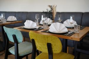 einen Tisch in einem Restaurant mit weißen Tellern und Stühlen in der Unterkunft Vorgebirgsblick - Restaurant Biergarten Gästehaus in Bornheim