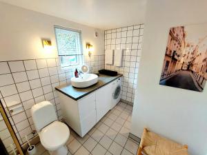 La salle de bains est pourvue de toilettes blanches et d'un lavabo. dans l'établissement Neptun Studio-apartment with terrace., à Copenhague