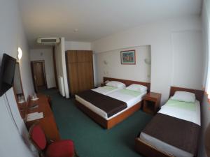 a hotel room with two beds and a flat screen tv at Hotel Saraj in Sarajevo