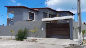 ein Haus mit einer Garagentür davor in der Unterkunft Casas Peroba Maragogi in Maragogi