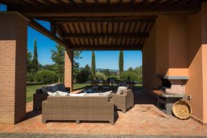 eine Terrasse mit Sofas, einem Kamin und einem Herd in der Unterkunft Villa Irene - Homelike Villas in Montelopio