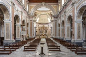 an empty church with rows of chairs in it at Unicum Suite Napoli Centro Storico in Naples