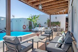 a patio with chairs and a swimming pool at Villa Fae in Playa Blanca