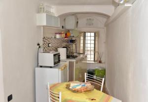 uma pequena cozinha com uma mesa e um frigorífico em LOVE NEST casa vacanze Ercolano em Ercolano