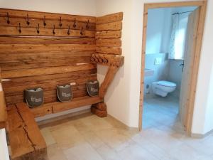 a bathroom with a wooden wall with a toilet at Ferienhaus am Kellpointhof in Miesbach +13 photos