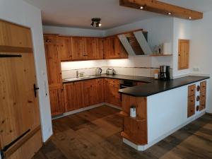 a kitchen with wooden cabinets and a black counter top at Ferienhaus am Kellpointhof in Miesbach
