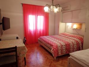 a room with two beds and a red curtain at Guest House Tinka in Starigrad