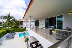 un balcon ouvert d'une maison avec piscine dans l'établissement Modern 4 Bedroom Pool Villa in Good Location VY, à Hua Hin