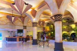 un hall avec colonnes et table dans un bâtiment dans l'établissement Villa del Palmar Beach Resort & Spa, à Cabo San Lucas