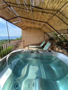 a jacuzzi tub under a wooden roof at Résidence Belvedere de Palombaggia in Porto-Vecchio