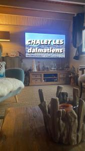 a living room with a tv and a wooden table at Camurac-Chalet les Dalmatiens in Camurac