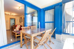 una sala da pranzo con pareti blu e tavolo e sedie di RESORT BEACH VALENCIA a Valencia