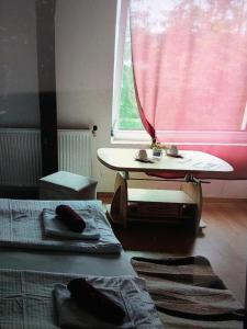 een kamer met twee bedden, een tafel en een raam bij Gesztenye apartman in Úrkút