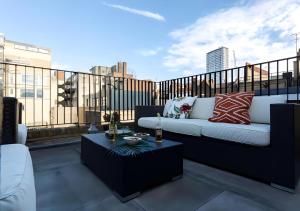 a balcony with a couch and a coffee table at StayLux Soho in London