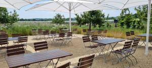 a group of tables and chairs under an umbrella at Vorgebirgsblick - Restaurant Biergarten Gästehaus in Bornheim