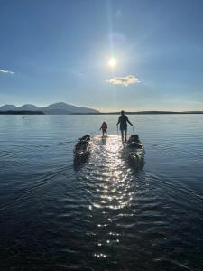 due persone sono in piedi su due barche in acqua di Granlunda Fjällgård a Duved