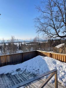 una terraza cubierta de nieve con una valla en Granlunda Fjällgård en Duved