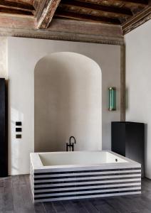 a large white bath tub in a room at Palazzo Petrvs in Orvieto
