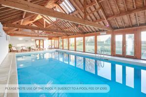 a swimming pool in a house with wooden ceilings at Host & Stay - Silton Hall in Nether Silton