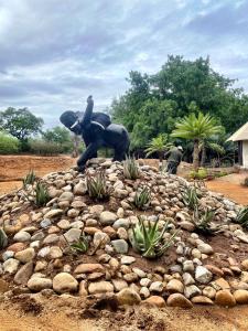 une statue d'une personne à bord d'un éléphant sur un tas de rochers dans l'établissement Karongwe Portfolio - Chisomo Safari Camp, à Karongwe Game Reserve