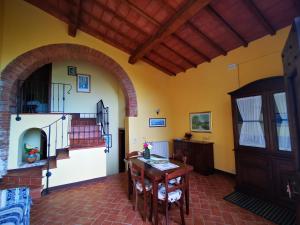 ein Wohnzimmer mit einem Tisch und einer Treppe in der Unterkunft Agriturismo Colle di Mezzo in Montefollonico