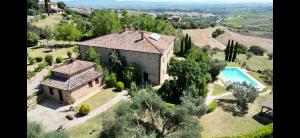 - une vue aérienne sur une grande maison avec une piscine dans l'établissement Agriturismo Colle di Mezzo, à Montefollonico