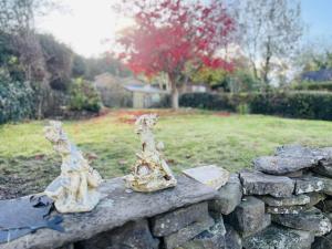 zwei Statuen auf einer Steinmauer in der Unterkunft Lovely Cottage with Mountain Views in Gilwern