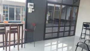Cette chambre comprend une table, des chaises et un comptoir. dans l'établissement Phontong Garden Resort, à Kalasin