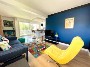 ein Wohnzimmer mit einem Sofa und einem gelben Stuhl in der Unterkunft Le Clos Boisé Résidence des Faunes in La Baule