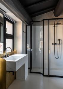 uma casa de banho com um lavatório branco e um chuveiro em Palazzo Petrvs em Orvieto