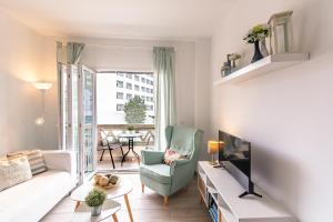 Andaluz Apartments Toboso في نيرخا: غرفة معيشة مع أريكة وتلفزيون