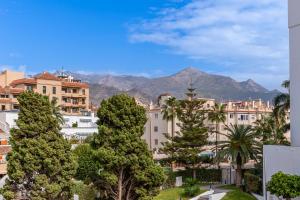 uma cidade com palmeiras e montanhas ao fundo em Andaluz Apartments Toboso em Nerja