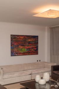 una sala de estar con sofá y una pintura en la pared en Set of Flats Vol 1 2 3, en Tríkala
